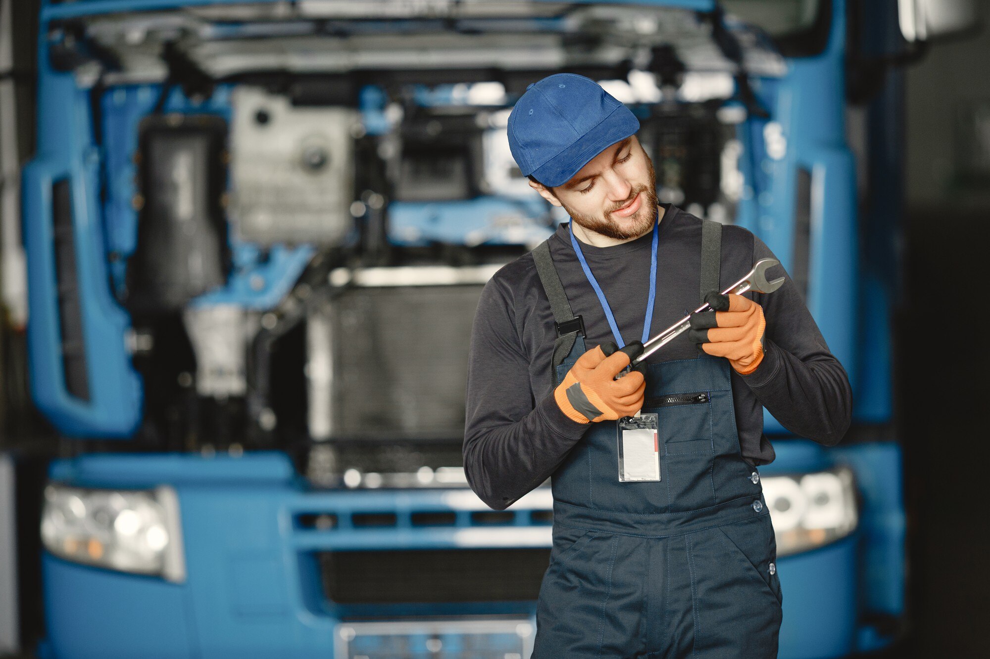 Worker Checking a Wrench While Repairing a Truck